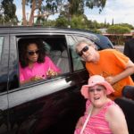Oprah Winfrey signing autograph with security guard watching