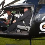Usain Bolt sitting in a helicopter with security guards
